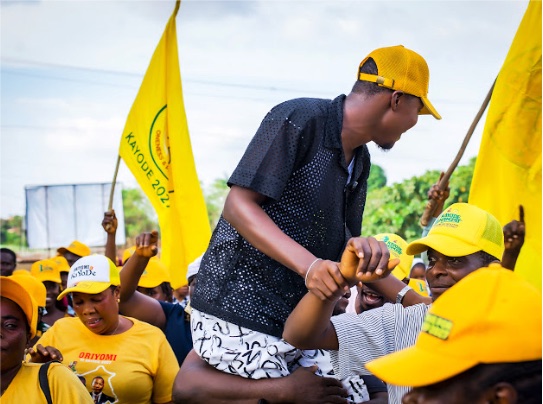 Kayode Hamzat greeting supporters while ACCORD flags fly overhead