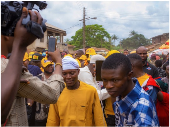 Kayode Hamzat walking a street in Ogbomoso South surrounded by supporters and press